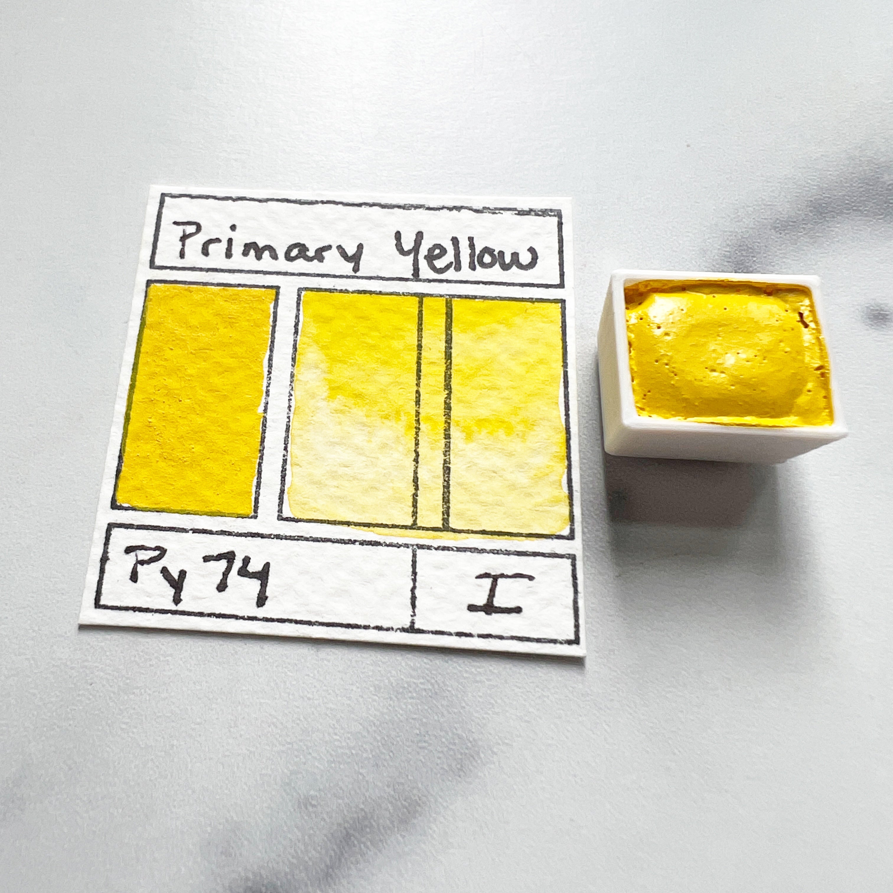 Primary Yellow. Half pan or bottle cap of handmade watercolor paint